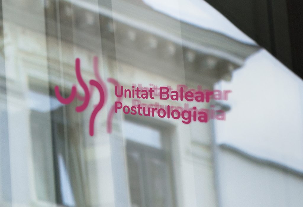 Aplicación del logo de le Unidad Balear de Posturología en un cristal